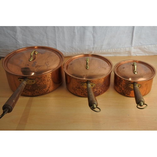 152 - A set of three copper lacquered lidded saucepans