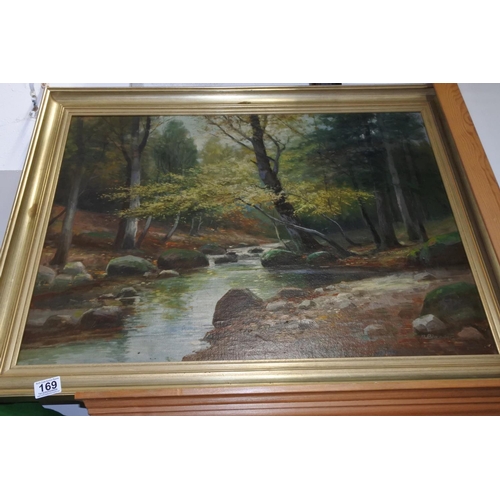 169 - A large framed oil painting of a forest scene signed by the artist. Measuring H-59cm W-78cm.