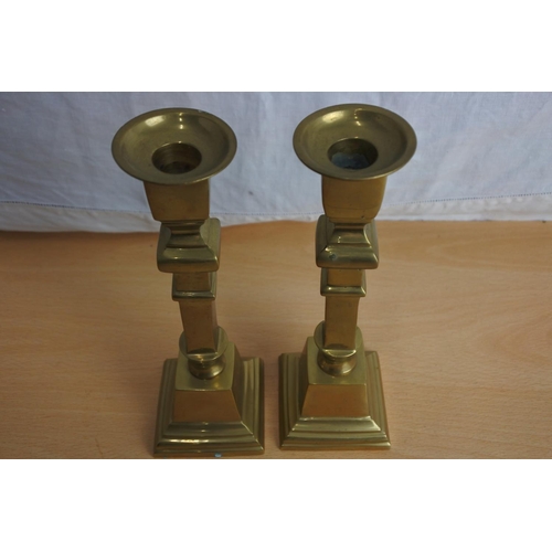 233 - A pair of antique brass candlesticks.