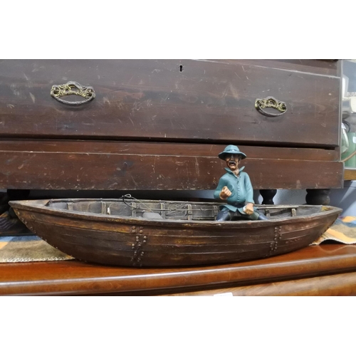 60 - An ornamental boat and fisherman.