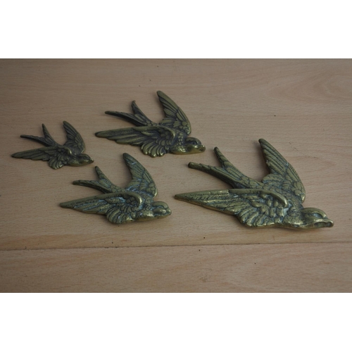 65 - A set of four brass flying bird wall plaques.