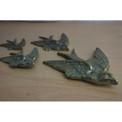 65 - A set of four brass flying bird wall plaques.