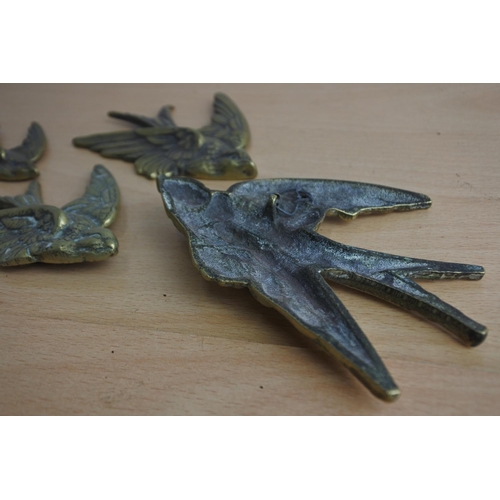 65 - A set of four brass flying bird wall plaques.