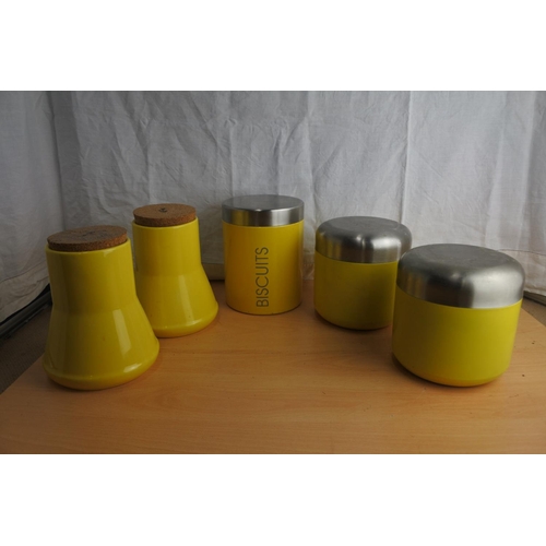 87 - 5 yellow metal cannisters.