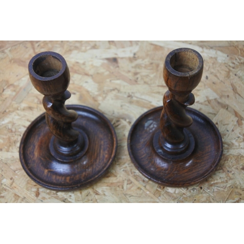 277 - A pair of turned oak candlesticks.