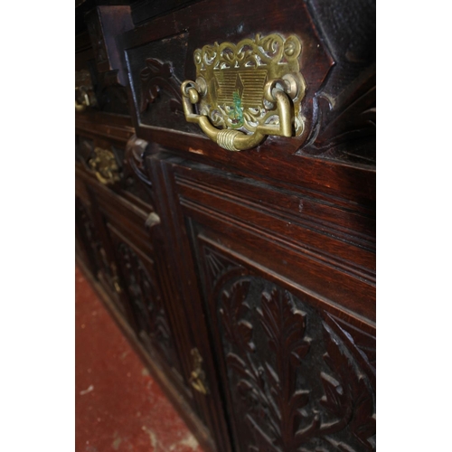 330 - A stunning antique ok four door sideboard with carved detail and original brass handles.