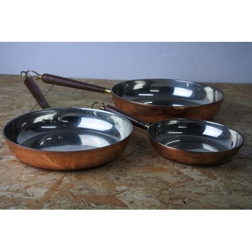 393 - A set of three copper pans.