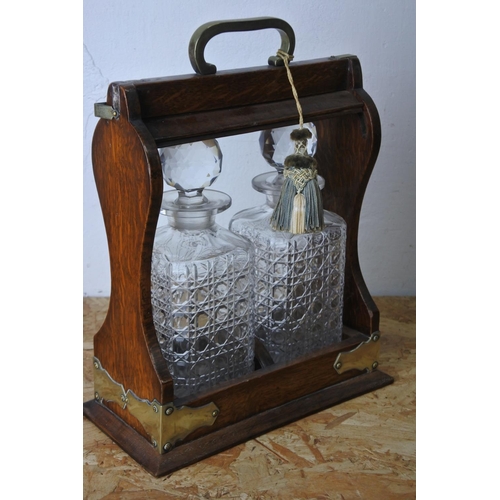 445 - A stunning antique oak cased tantalus with two glass decanters. (lacking key)