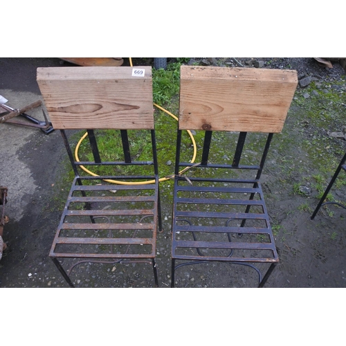 669 - A pair of metal framed garden chairs with wooden backs.