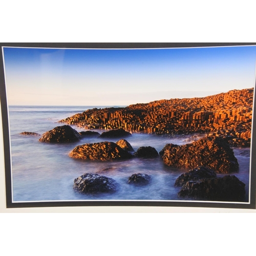 704 - A framed photograph of the 'Giants Causeway at Evening' by photographer Jonathan Leathem.