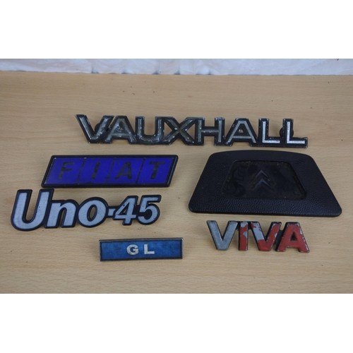 38 - A collection of car badges to include Fiat, Vauxhall and more.