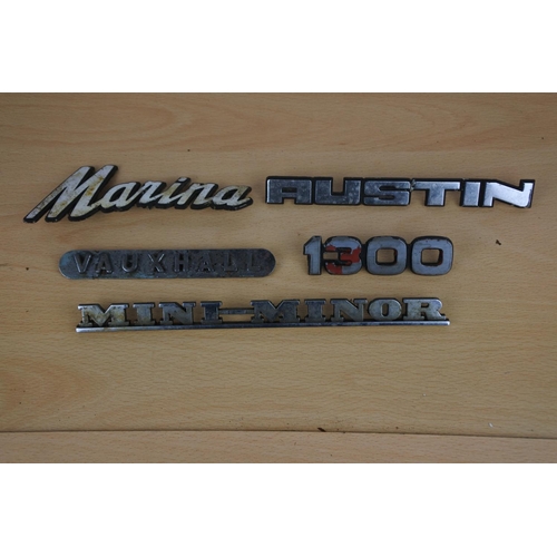 51 - A collection of vintage car badges to include 1300, Vauxhall and more.