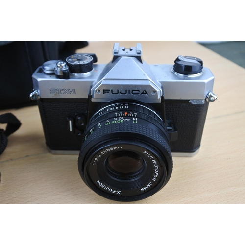 562 - A Canon camera bag containing a Minolta HI Matic F and case, a Fujica STX1 camera and a Pentax ME su... 