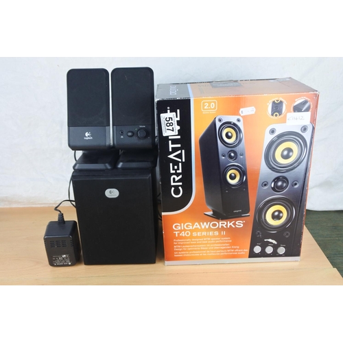587 - A boxed Gigaworks T40 Series II speaker box and a set of Logitech speakers .