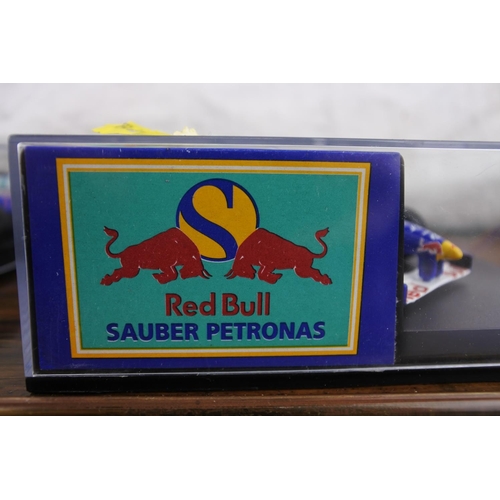 41 - Two cased Red Bull Sauber Petronas 1997 Formula One cars, racing driver Nicola Larini.