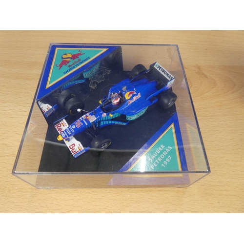 129 - A cased Red Bull Sauber Petronas 1997 Formula One cars, racing driver Johnny Herbert and a cased Vit... 