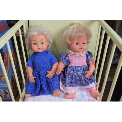 354 - An old toy doll's cot with 2 Palitoy Tiny Tears Dolls