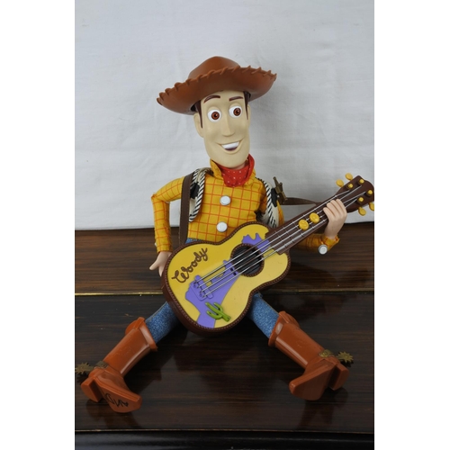 357 - An unboxed (working) Strummin, Singing and Whistling Woody Figure and another.