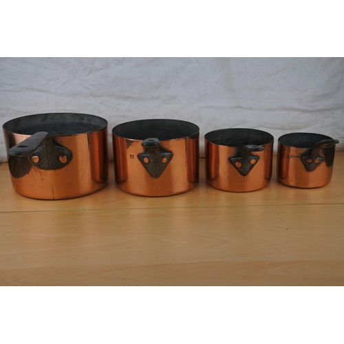 75 - A set of four antique copper saucepans.