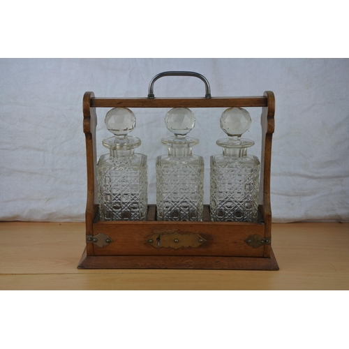 82 - A stunning antique three glass decanter tantalus with key.