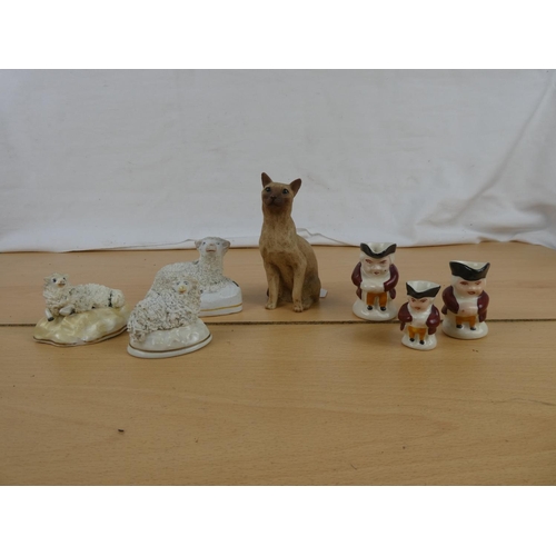 113 - A set of three miniature mask jugs, three Staffordshire sheep ornaments and more.