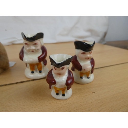 113 - A set of three miniature mask jugs, three Staffordshire sheep ornaments and more.