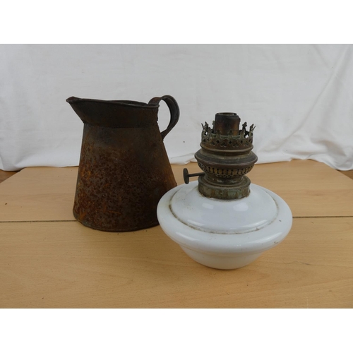 117 - An antique ceramic oil lamp font and an old metal jug.