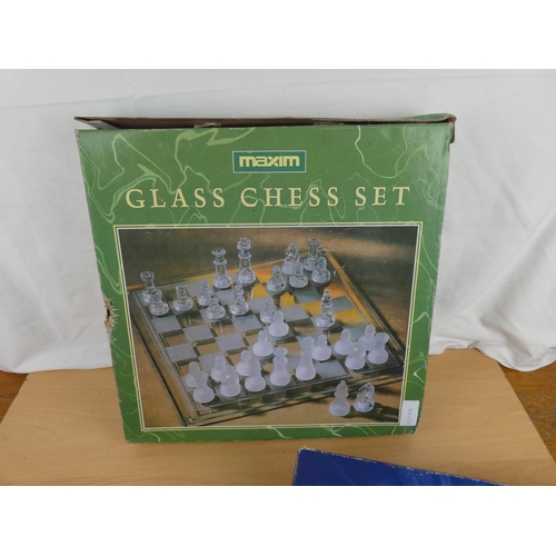 133 - A boxed glass chess set, a Millionaire board game and a boxed Solitaire game.