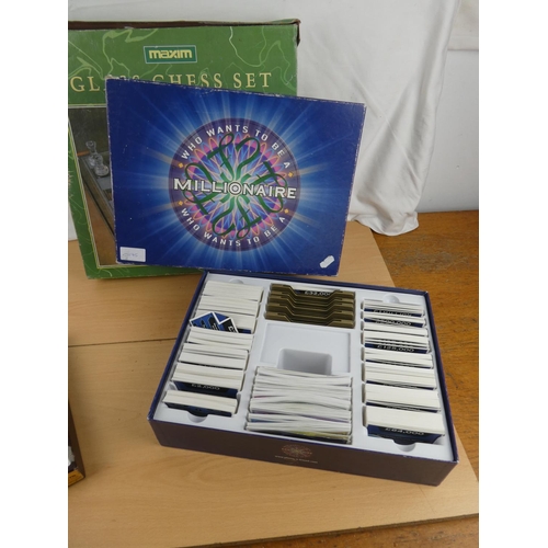 133 - A boxed glass chess set, a Millionaire board game and a boxed Solitaire game.