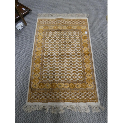 142 - A vintage orange and brown patterned mat. Approx 108x69cm.