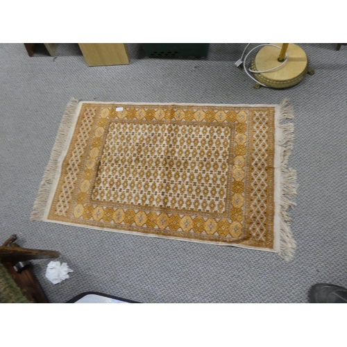 142 - A vintage orange and brown patterned mat. Approx 108x69cm.