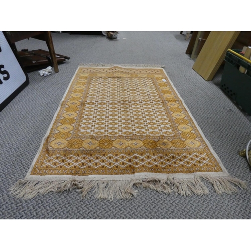 142 - A vintage orange and brown patterned mat. Approx 108x69cm.