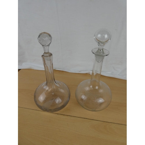 156 - Two antique glass decanters with etched design.