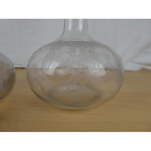 156 - Two antique glass decanters with etched design.