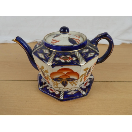 166 - An antique teapot and stand.