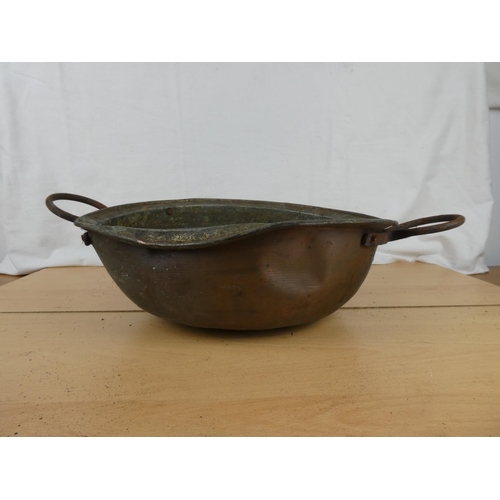 186 - An antique two handled copper bowl.