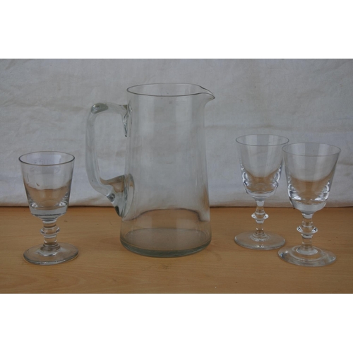 268 - A vintage glass water jug and three glasses.