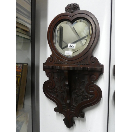 329 - A mahogany wall bracket with heart shaped mirror. Approx 66x32cm.