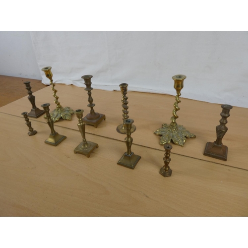 337 - A collection of miniature brass candlesticks.