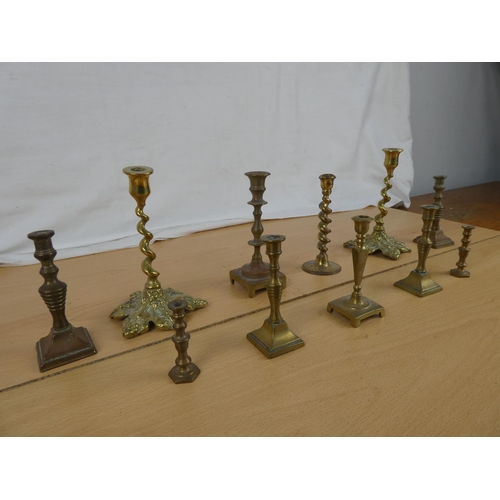 337 - A collection of miniature brass candlesticks.