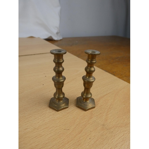 337 - A collection of miniature brass candlesticks.