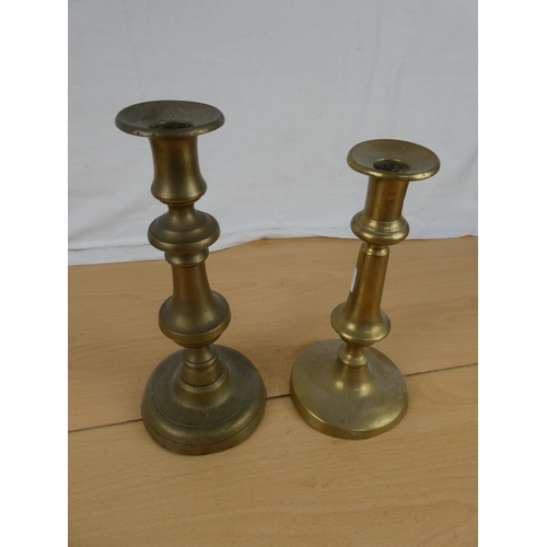 351 - Two brass candlesticks. Approx 20cm and 23cm.