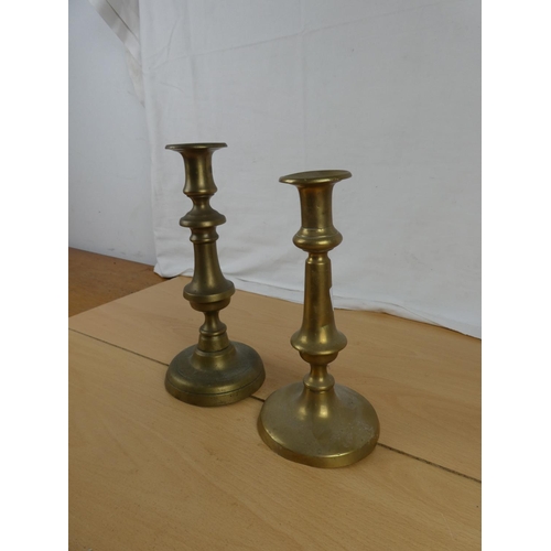 351 - Two brass candlesticks. Approx 20cm and 23cm.