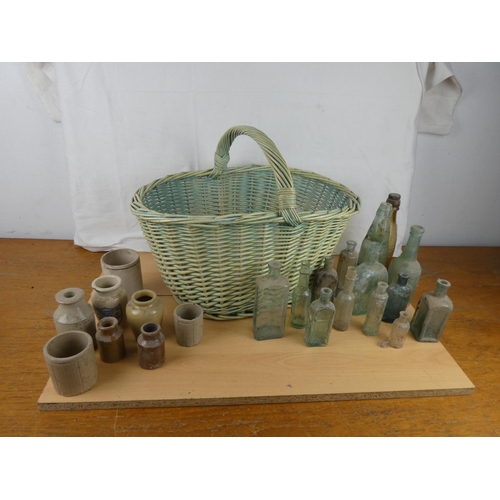 363 - A large wicker shopping basket and a collection of stoneware jars and glass bottles.