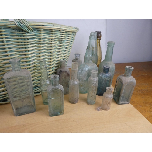 363 - A large wicker shopping basket and a collection of stoneware jars and glass bottles.