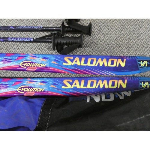 128 - A pair of Salomon snow skis and storage bag. Approx 187cm.