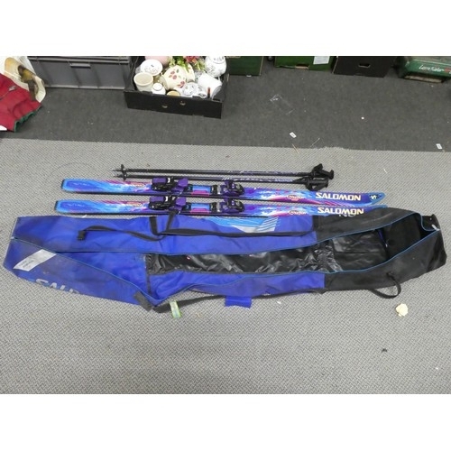 128 - A pair of Salomon snow skis and storage bag. Approx 187cm.