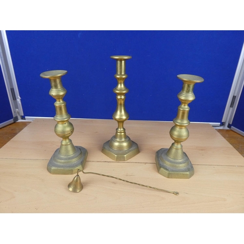 505 - Three brass candlesticks and a brass candle snuffer.