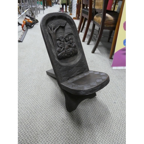 528 - A carved African tribal art folding stool.