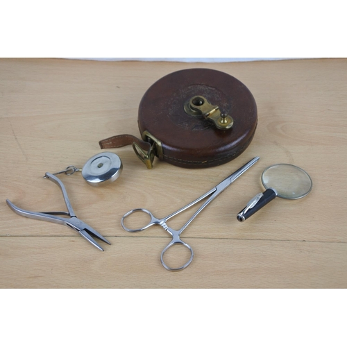 602 - A vintage leather cased Hockley & Abbey tape measure, a miniature magnifying glass and more.